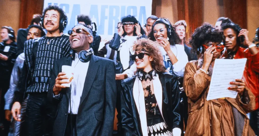 Cantores ensaiam com entusiasmo a letra de We Are The World para o álbum histórico.