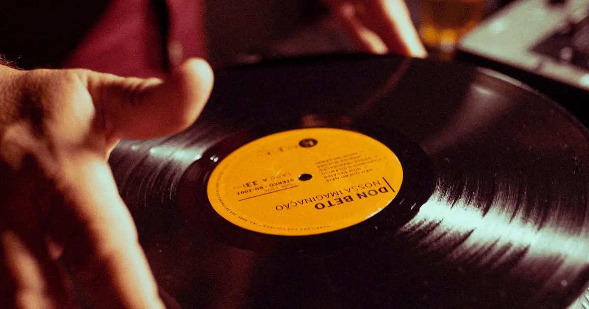Um amante da música segura com paixão seu álbum em formato de vinil.